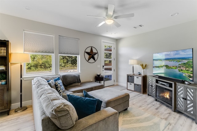 living room with light hardwood / wood-style flooring and ceiling fan