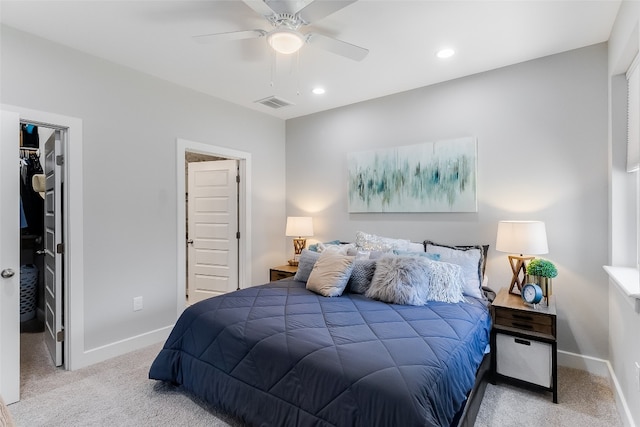 carpeted bedroom with a closet, ceiling fan, and a walk in closet