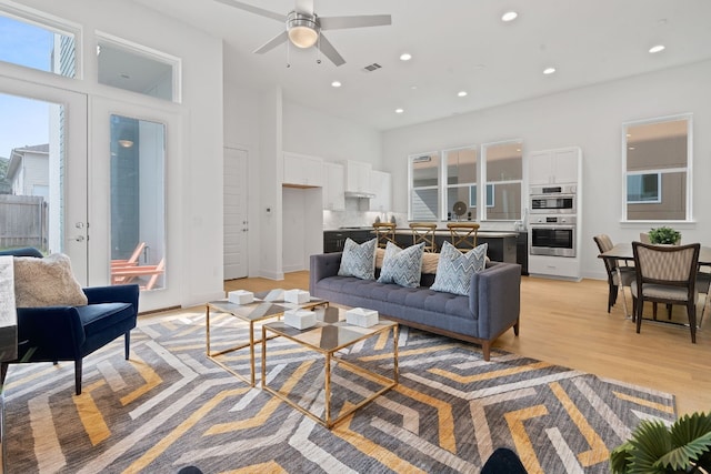 living room featuring ceiling fan and light wood-type flooring