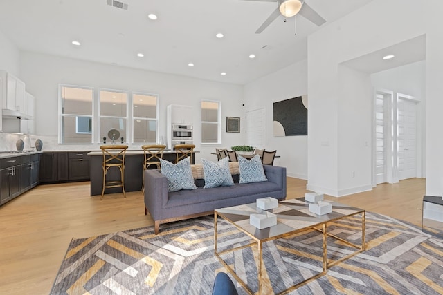 living room with ceiling fan and light hardwood / wood-style floors