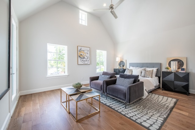 bedroom featuring multiple windows, ceiling fan, hardwood / wood-style floors, and high vaulted ceiling