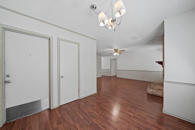 unfurnished living room featuring ceiling fan, dark hardwood / wood-style flooring, and a textured ceiling