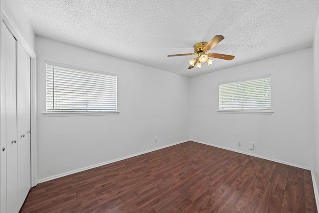 unfurnished room featuring dark wood-type flooring, ceiling fan, and a textured ceiling