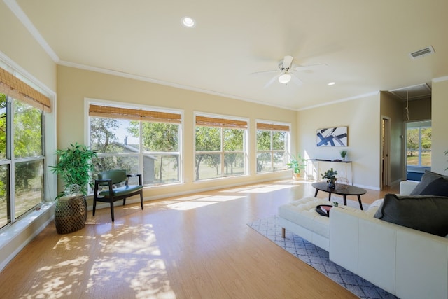 living room with a wealth of natural light, ceiling fan, ornamental molding, and hardwood / wood-style floors