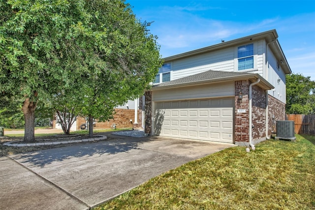 view of property with cooling unit, a garage, and a front lawn