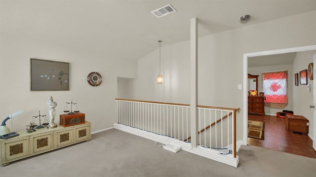 hallway with carpet and vaulted ceiling