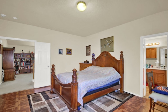 bedroom with connected bathroom and dark parquet floors