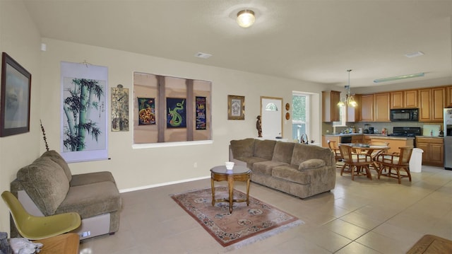 living room with a notable chandelier and light tile patterned floors