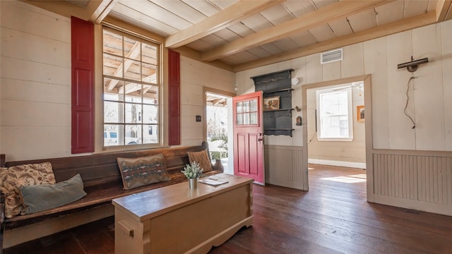 living room featuring wood walls, wooden ceiling, beamed ceiling, and dark wood-type flooring