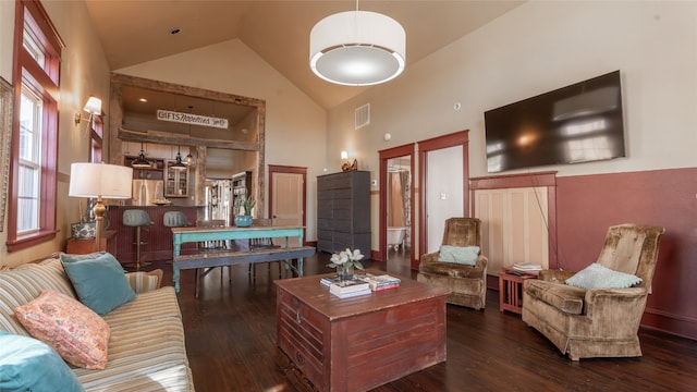 living room with dark wood-type flooring and high vaulted ceiling