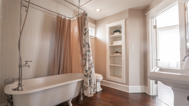 full bathroom featuring sink, shower / tub combo, built in features, hardwood / wood-style floors, and toilet