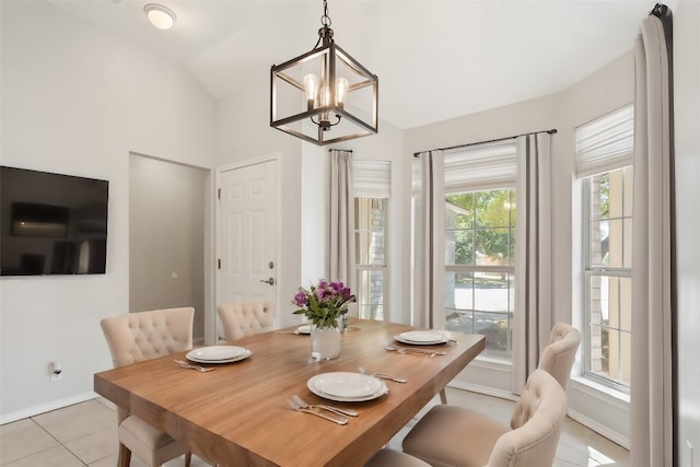 tiled dining room with vaulted ceiling and an inviting chandelier