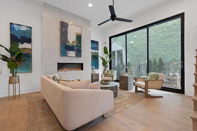 living room with ceiling fan, light hardwood / wood-style flooring, and a wealth of natural light