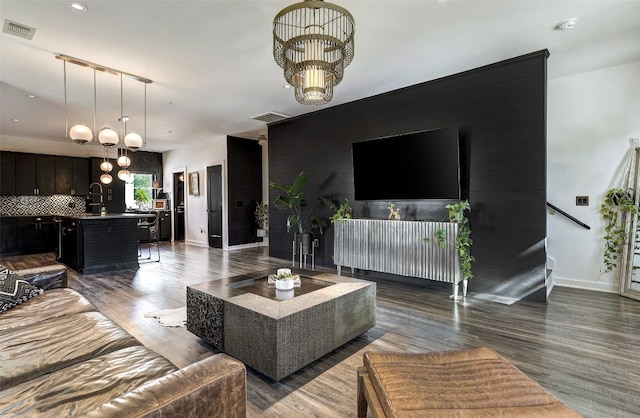 living room featuring dark hardwood / wood-style floors, a chandelier, and sink