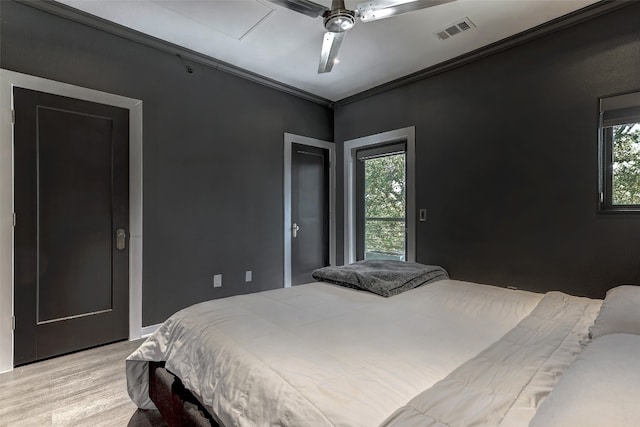 bedroom featuring light wood-type flooring, multiple windows, ceiling fan, and ornamental molding