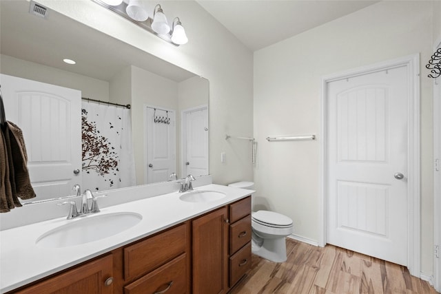 bathroom with hardwood / wood-style floors, toilet, and vanity