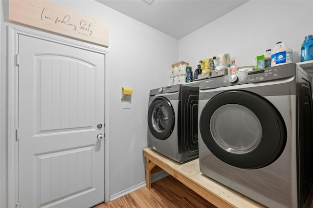 laundry area with washer and clothes dryer and wood-type flooring