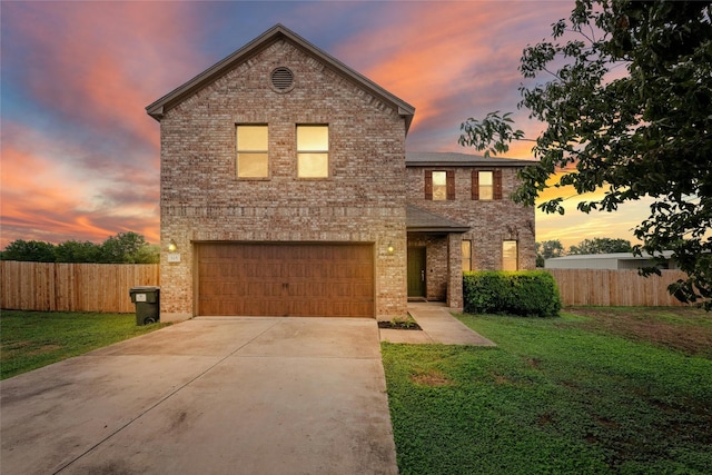 traditional home featuring fence, an attached garage, driveway, a front yard, and brick siding