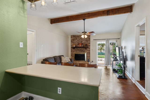 kitchen with lofted ceiling with beams, ceiling fan, and a fireplace