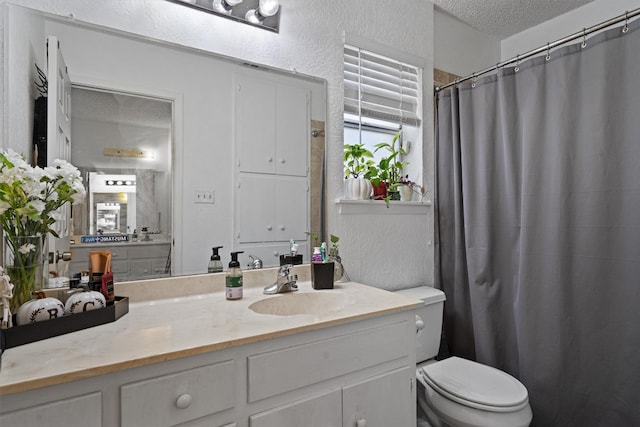 bathroom with vanity, a textured ceiling, and toilet