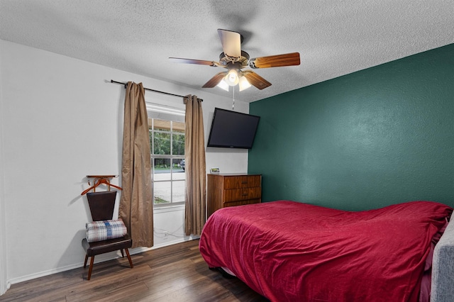 bedroom featuring dark hardwood / wood-style flooring, a textured ceiling, and ceiling fan