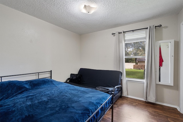 bedroom with dark wood-type flooring and a textured ceiling