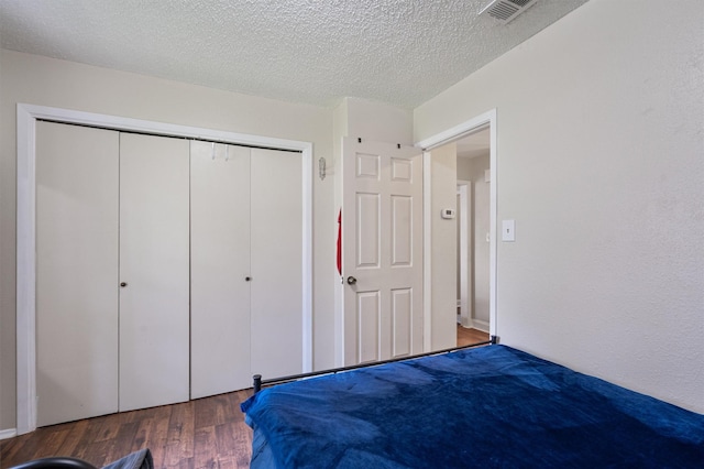 unfurnished bedroom with dark hardwood / wood-style flooring, a closet, and a textured ceiling