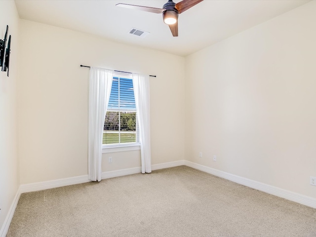 spare room featuring light colored carpet and ceiling fan