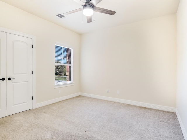 unfurnished room featuring ceiling fan and light colored carpet