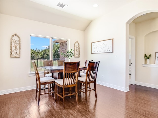 dining space featuring dark wood-type flooring and lofted ceiling