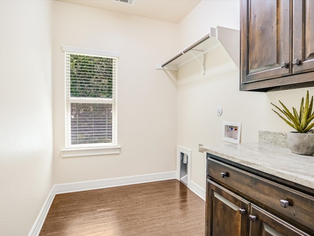 laundry room featuring electric dryer hookup, hookup for a washing machine, wood-type flooring, and cabinets