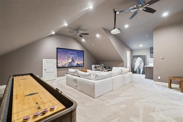 home theater room with ceiling fan, light carpet, and vaulted ceiling