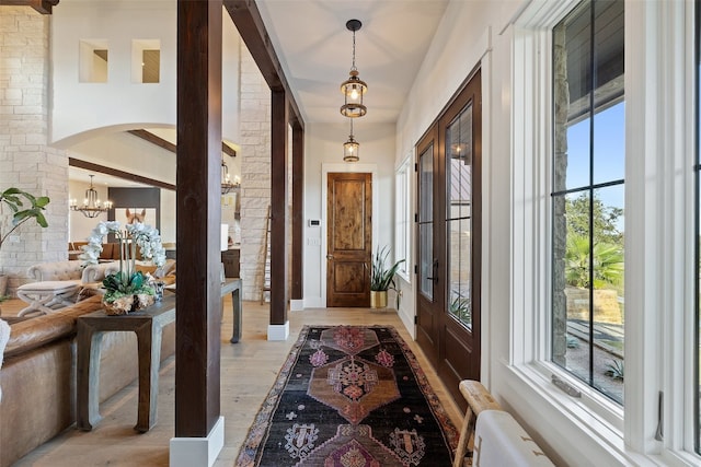 foyer with light hardwood / wood-style flooring and an inviting chandelier