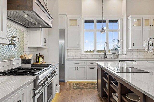 kitchen featuring light hardwood / wood-style flooring, white cabinetry, sink, extractor fan, and double oven range