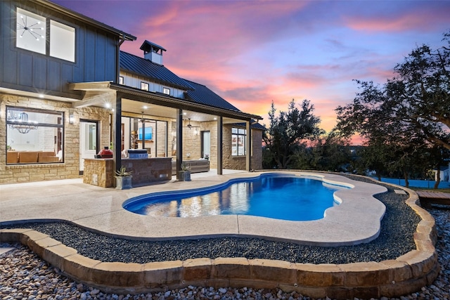 pool at dusk with a patio area