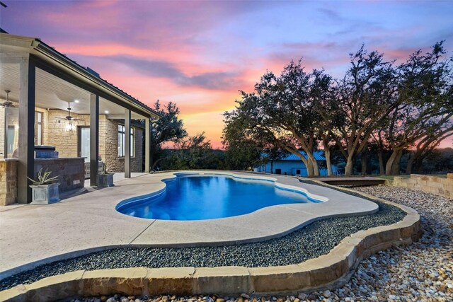 pool at dusk with a patio