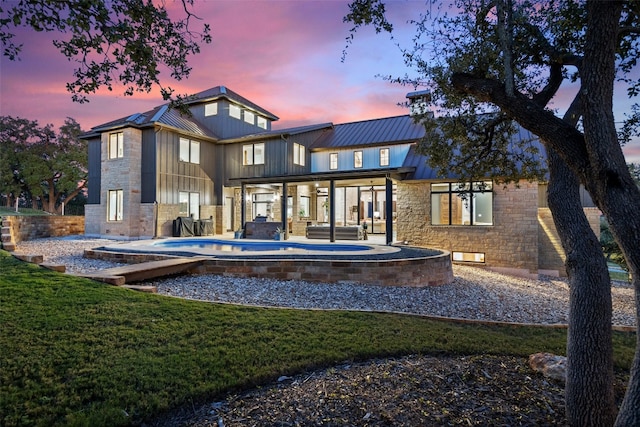 back house at dusk with a yard and a patio area