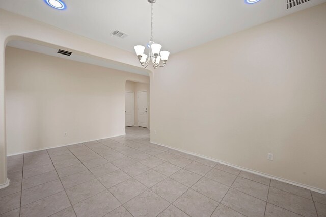 empty room featuring light tile patterned floors and a notable chandelier