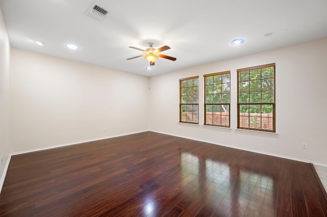 empty room with ceiling fan and dark hardwood / wood-style floors