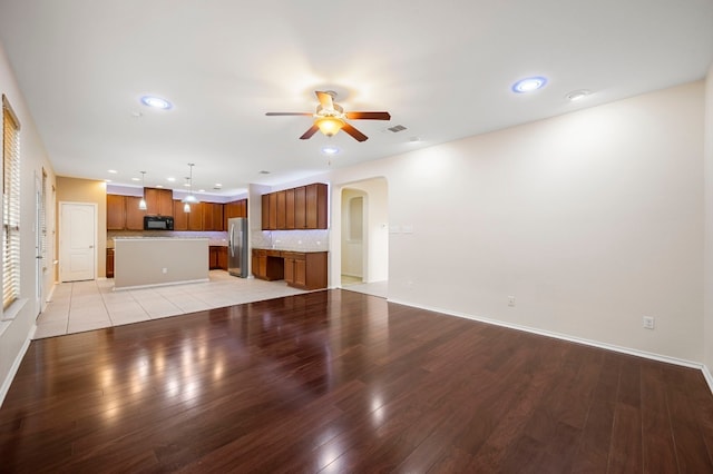 unfurnished living room featuring light hardwood / wood-style flooring and ceiling fan