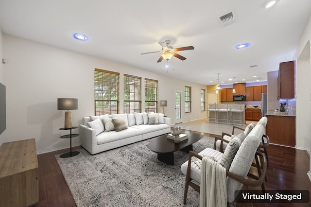 living room with dark hardwood / wood-style flooring and ceiling fan