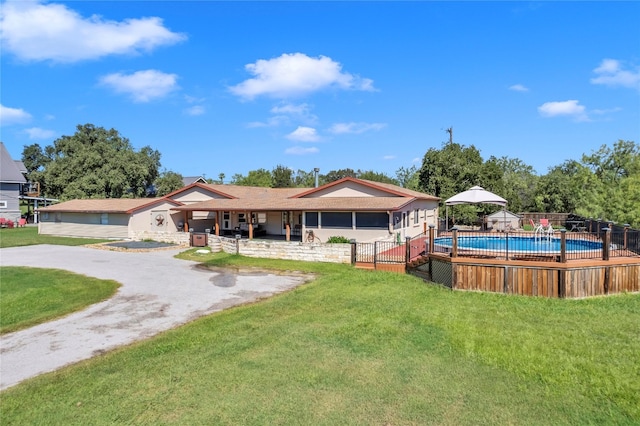 back of property with a fenced in pool, a yard, and a patio