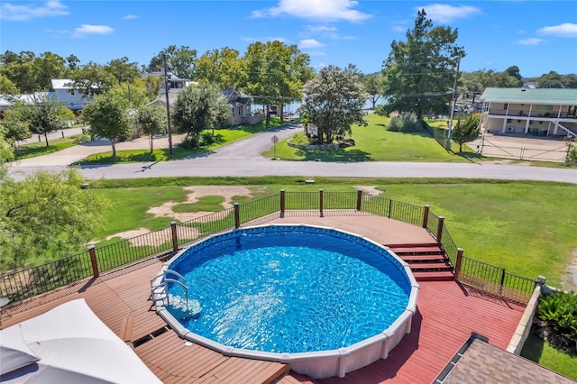 view of swimming pool featuring a yard and a deck