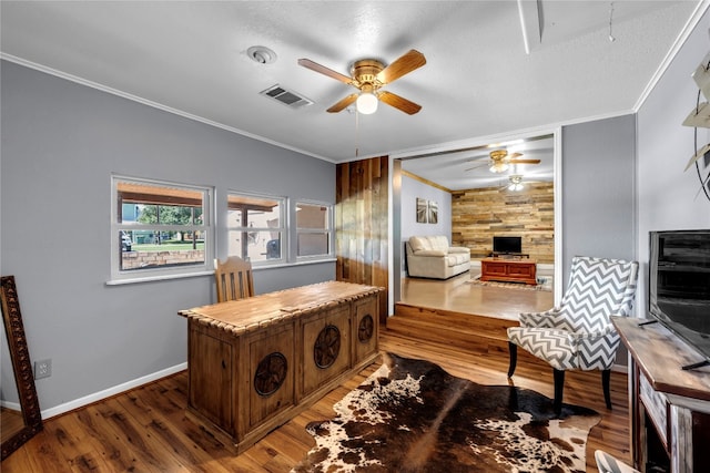 home office with crown molding, wood-type flooring, wood walls, and ceiling fan