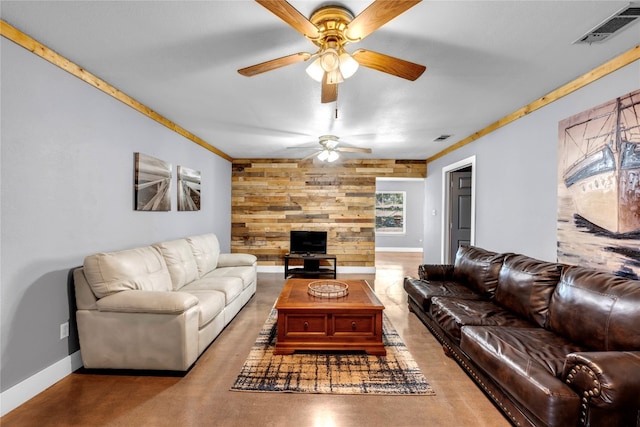 living room featuring ornamental molding, ceiling fan, and wooden walls