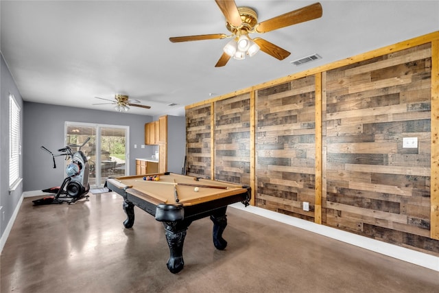 recreation room with pool table, concrete flooring, ceiling fan, and wooden walls