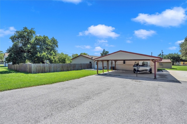 view of front of property featuring a front lawn, a carport, and a garage