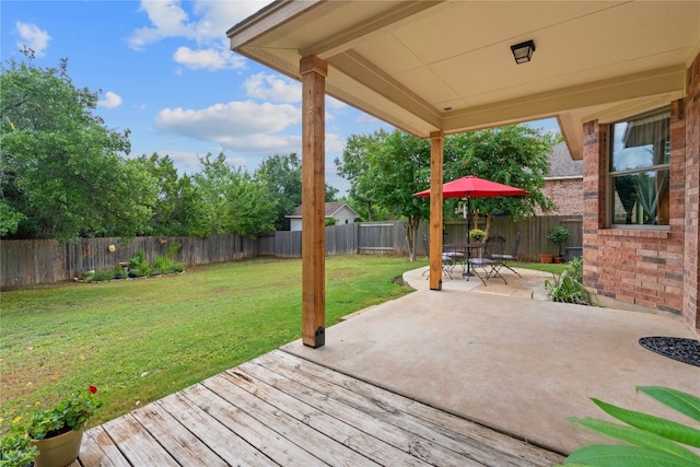 wooden terrace with a yard and a patio