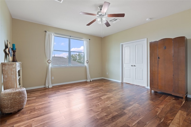 bedroom with a closet, dark hardwood / wood-style floors, and ceiling fan