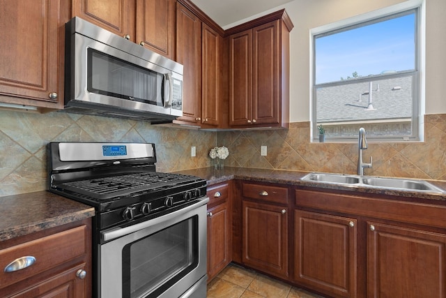 kitchen with tasteful backsplash, appliances with stainless steel finishes, sink, and light tile patterned floors